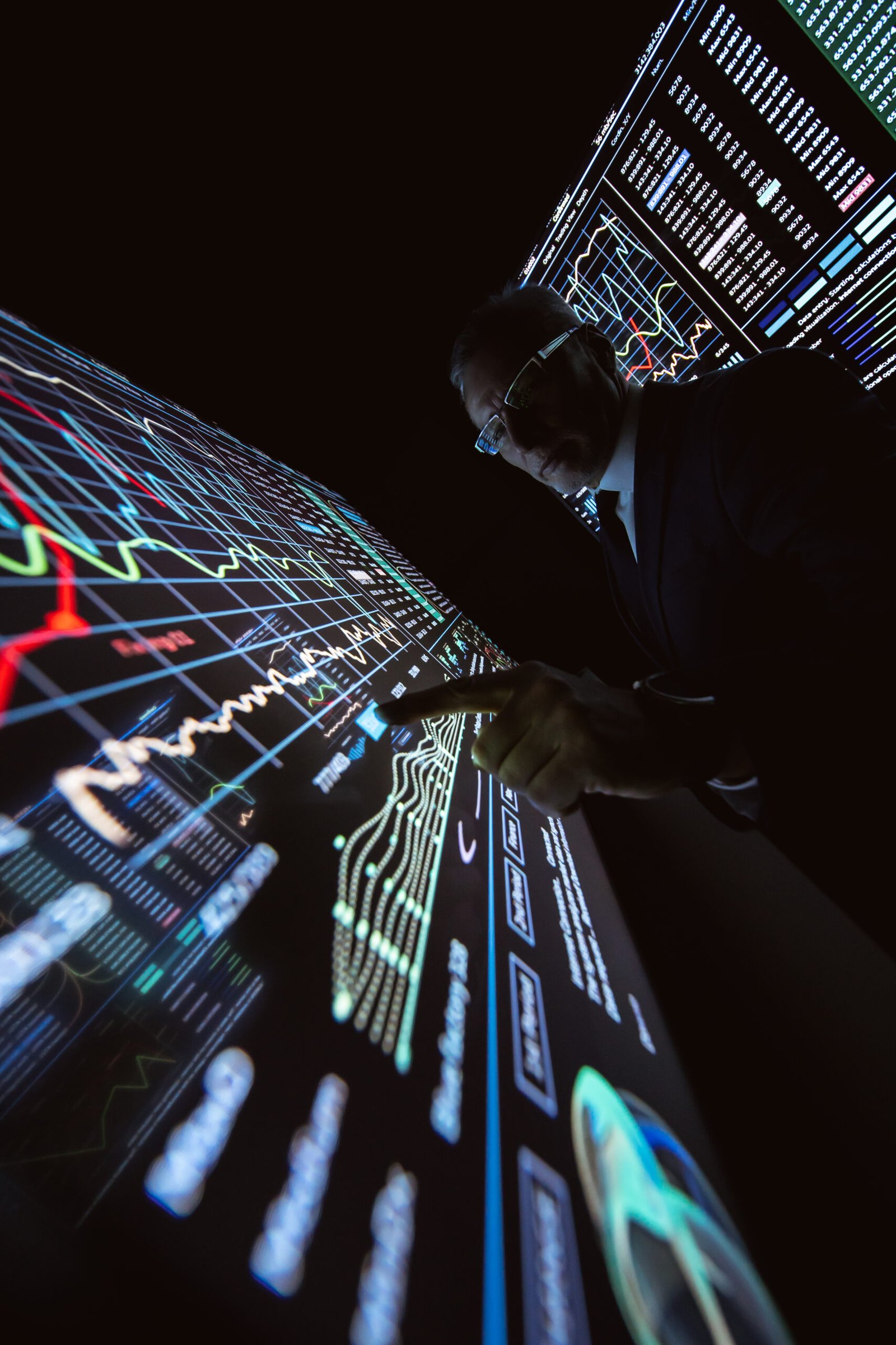 The man working on the big sensor display in the dark lab